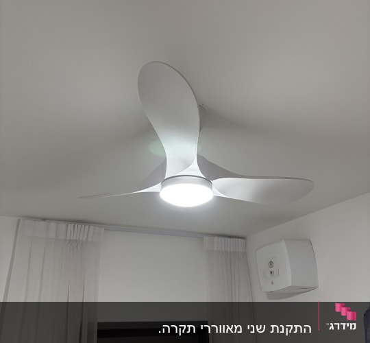 מאוורר תקרה עם תאורה בחדר עם וילונות לבנים